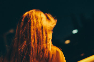 Rear view of woman against black background