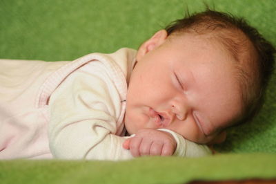 Close-up of cute baby sleeping at home