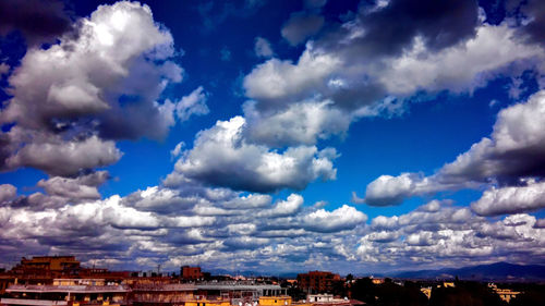 View of cityscape against cloudy sky