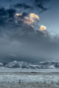 Scenic view of snowy field against sky