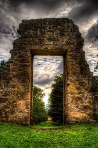 Abandoned house on field against sky