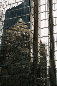 Low angle view of building seen through glass window
