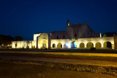 Illuminated building against blue sky at night