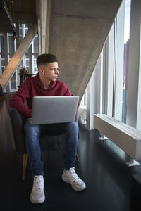 Full length of young man using laptop