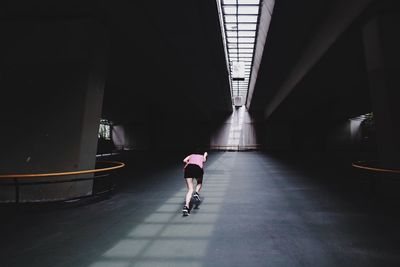 Rear view of woman walking on road