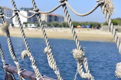 Close-up of rope tied to bollard against sky