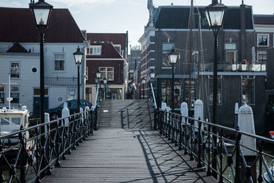 Empty footpath amidst buildings in city