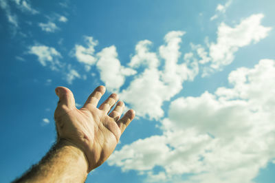 View of human hand against sky