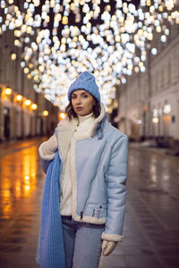 A woman in blue clothes walks along an empty street at night in moscow in winter