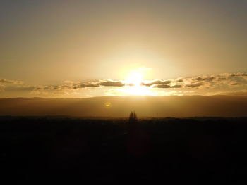 Scenic view of silhouette field against sky during sunset