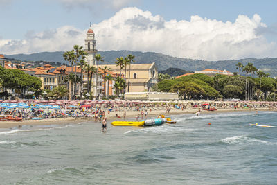 Scenic view of sea by buildings against sky