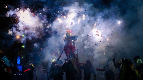 Men igniting fireworks at night during celebration