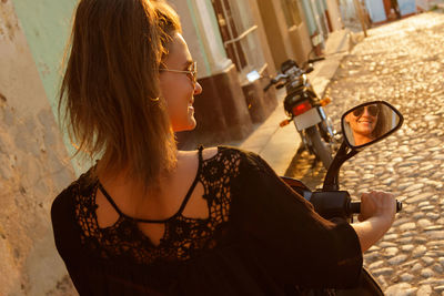 Side view of young woman holding camera