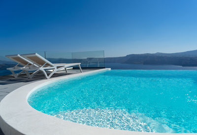 Lounge chair and pool over santorini caldera. akrotiri, santorini island, cyclades, greece, europe.