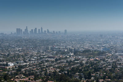 Aerial view of buildings in city against clear sky