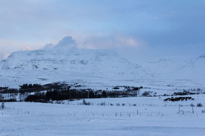 Scenic view of snow covered land against sky