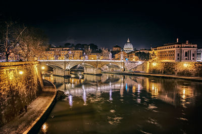 Bridge over river in city at night