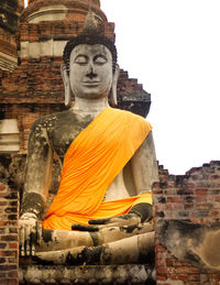 Statue against temple building against sky