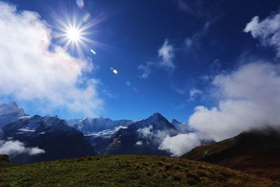 Scenic view of snowcapped mountains against cloudy sky