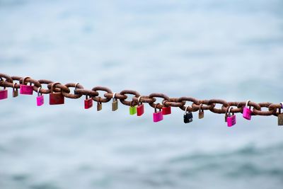 Close-up of padlocks on chain against sky