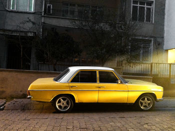 Yellow car parked on street in city