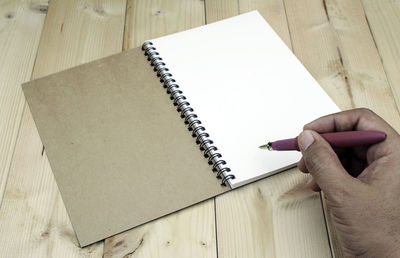 High angle view of person reading book on table
