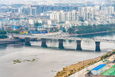 High angle view of bridge over river by buildings in city