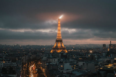 Illuminated buildings in city against sky at night