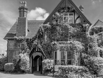 Exterior of old building by trees and houses