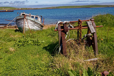 Abandoned boat on shore by lake