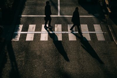 Low section of people walking on zebra crossing