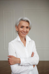 Close up portrait of beautiful older woman standing by wall