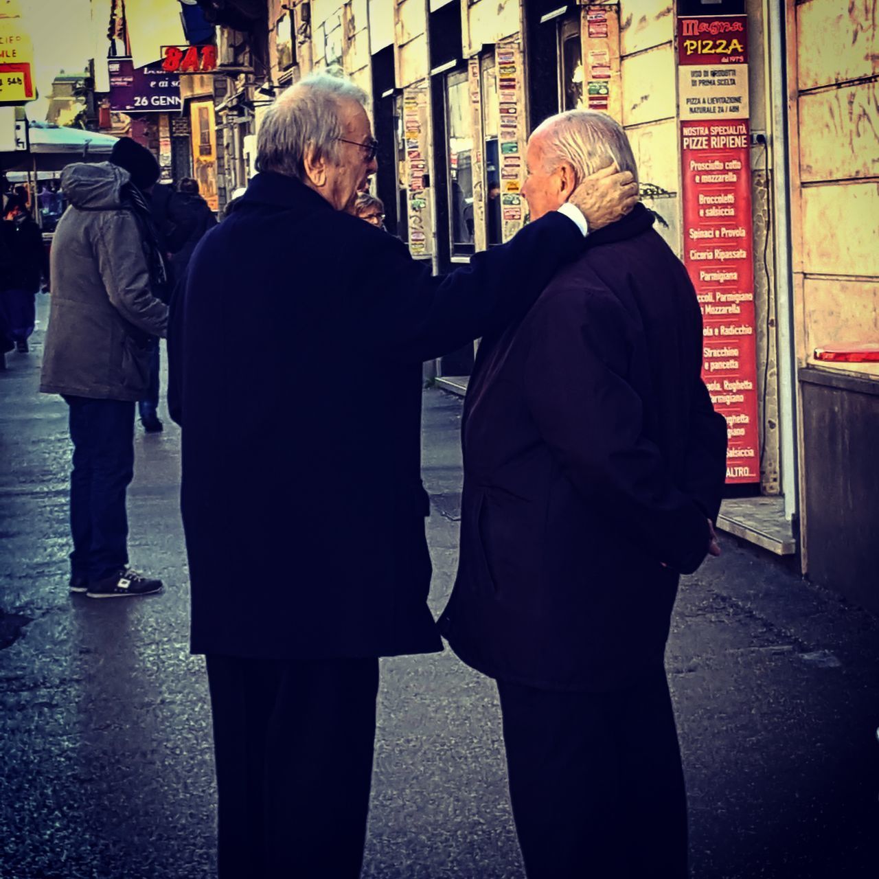 REAR VIEW OF COUPLE STANDING ON STREET