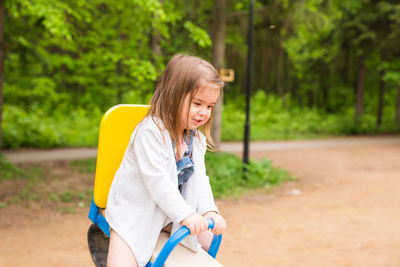 Portrait of young woman standing against trees