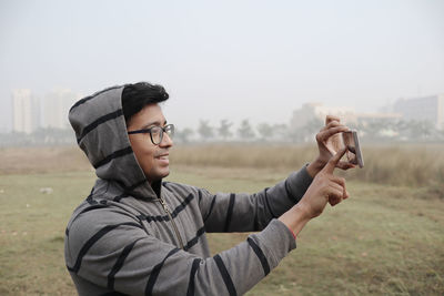 Side view of young man standing on field