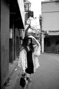 Young woman standing on road in city