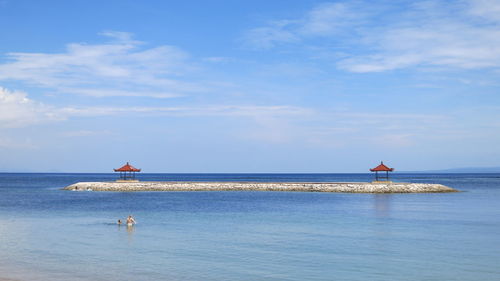 Scenic view of calm sea against cloudy sky