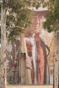 Portrait of man standing by tree