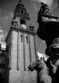 Low angle view of statue amidst buildings against sky