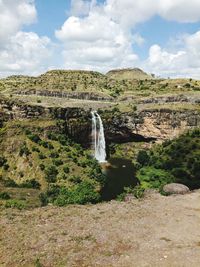 Scenic view of waterfall against sky