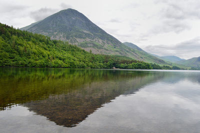 Scenic view of lake by mountains against sky