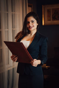 Portrait of a smiling young woman standing at home