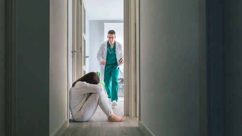 Side view of woman looking through window