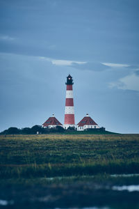 Lighthouse by sea against sky