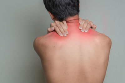 Rear view of shirtless man against white background