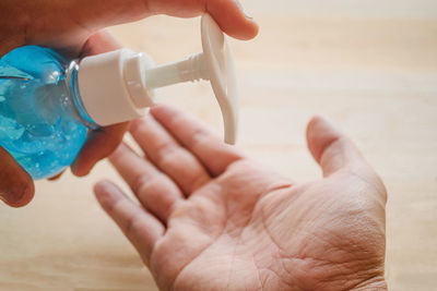 Cropped image of hand holding drinking glass bottle