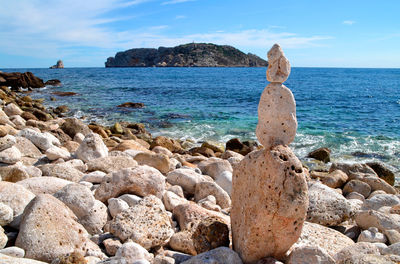 Scenic view of rocks on beach against sky