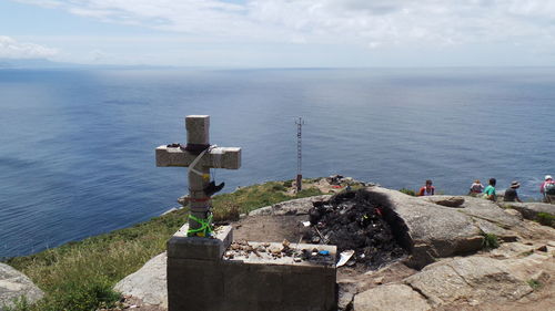 High angle view of cross on rock formation by sea