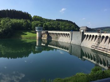 Arch bridge over lake against sky