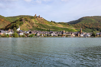 Scenic view of town by sea against sky